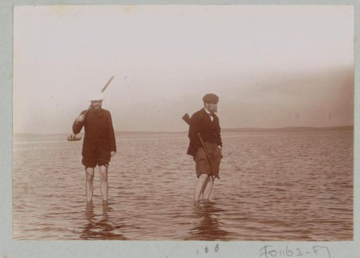 Hunters wading through the water, probably on the coast at Arcachon