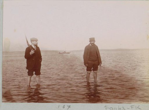 Hunters wading through the water, probably on the coast at Arcachon