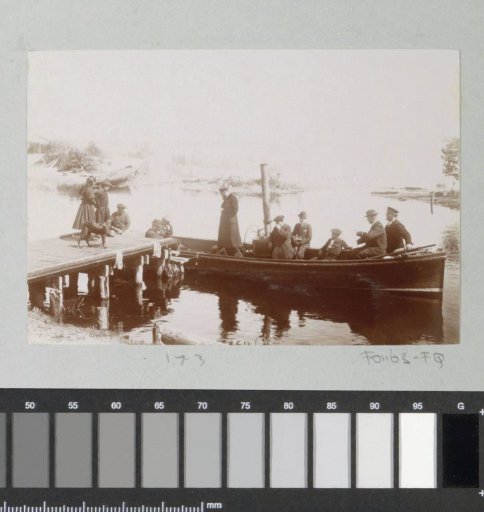 Group with children in a motorboat at a pier in France