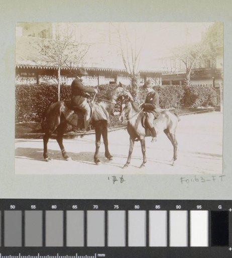 Two men on horseback in a street in France