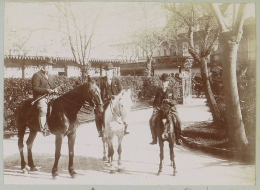Three men on horseback in a street in France