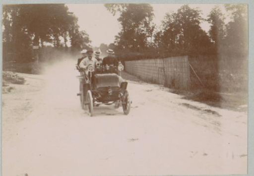 Group in an automobile on a dusty country road near L'Isle-Adam