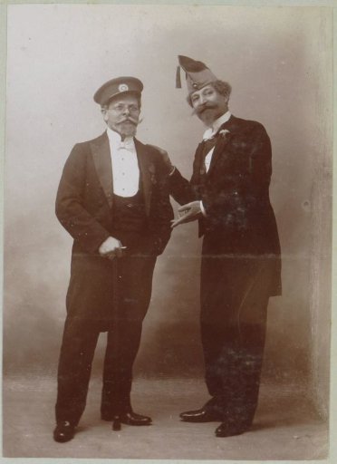 Portrait of Two Men in Festive Attire with Headgear, Probably in France