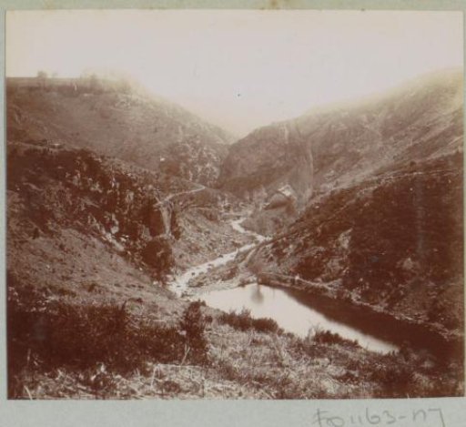 View of a valley with road, house and water, probably in the Auvergne
