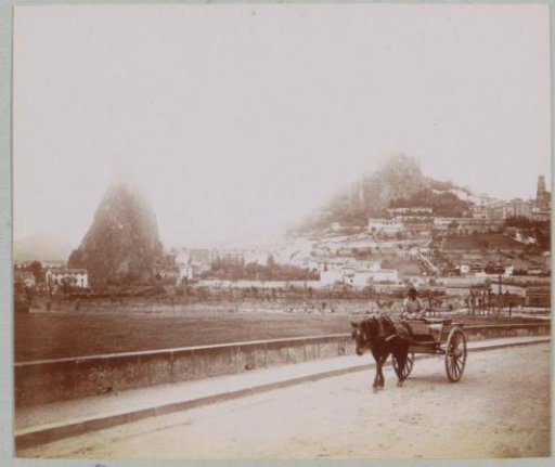 View of rock formations in Le Puy-en-Velay with a horse-drawn cart in the foreground