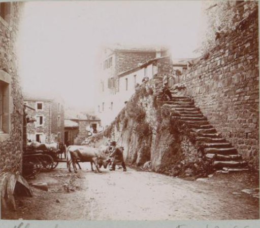 Street scene in Chanteuges with an ox-cart, stairs and children