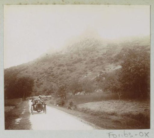 Woman in an automobile on a country road, probably in the Auvergne