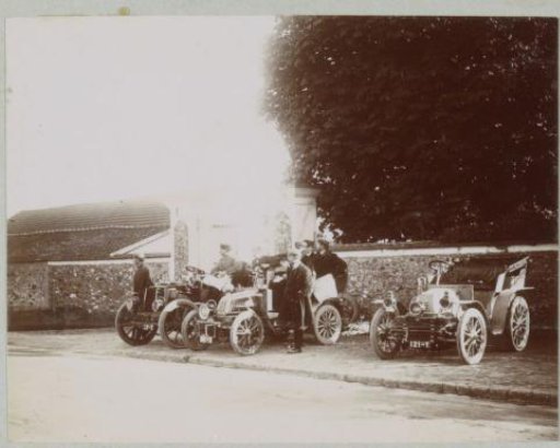 Spectators at the Paris-Vienna automobile race with their vehicles parked on a sidewalk