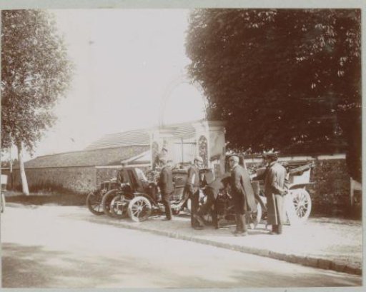 Spectators at the Paris-Vienna automobile race with their vehicles parked on a sidewalk