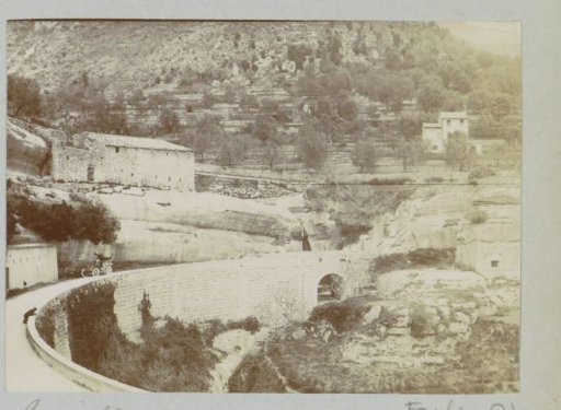 View of Tourrettes-lès-Vence with an Automobile in a Road Bend