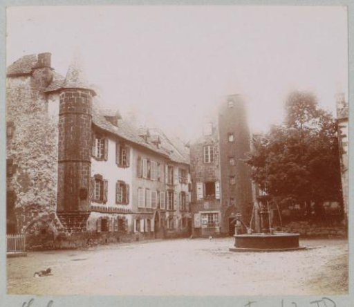 Square with fountain and towers in Salers