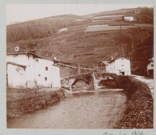 River with bridge and houses, probably in the Spanish Basque Country