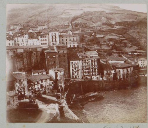 View of a town against a mountain on a body of water, possibly in the French or Spanish Basque Country