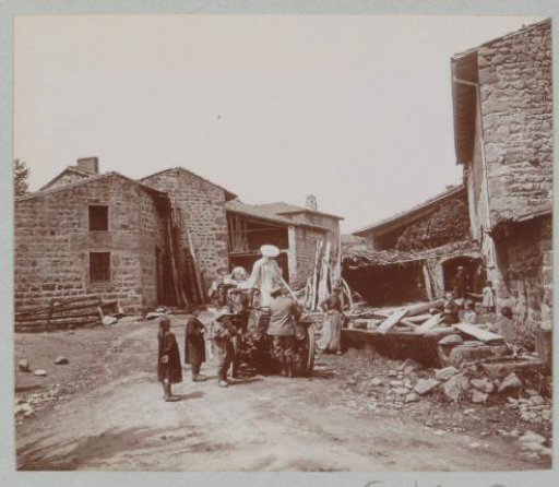 Children looking at an automobile on a farmyard, probably in the Auvergne