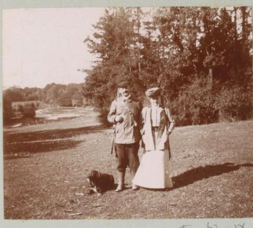 A woman, a man with a hunting rifle and a dog, probably in France