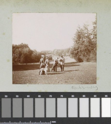 Three women, a man with a hunting rifle and two dogs, probably in France