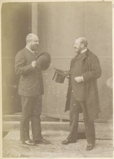 Portrait of two French men with hats, standing in front of a metal vat