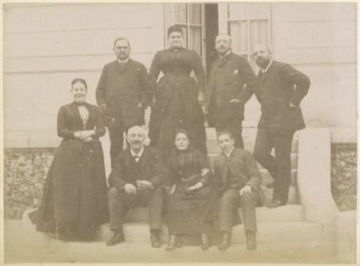 Group portrait of a French family on the steps in front of a house