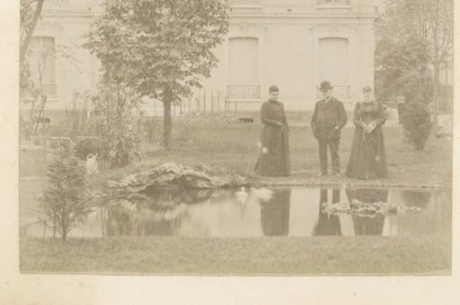 Three people by a pond in a garden in France