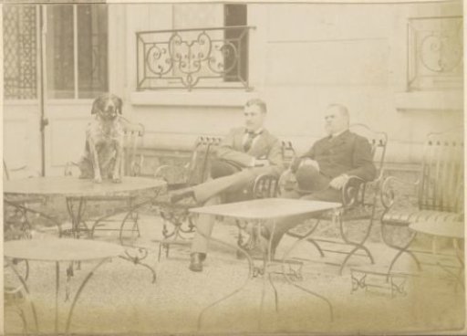Two men and a dog in a garden in France