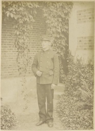 Portrait of a French boy in a uniform in a garden