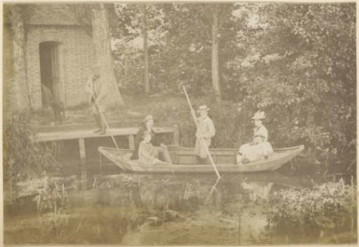 Family with three children in a rowing boat on a ditch in France, a man pushing off from the bank