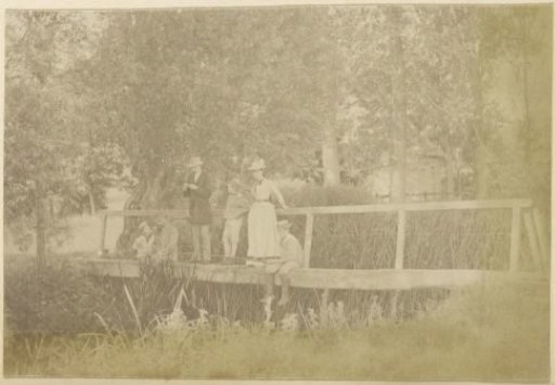 Family with three children fishing on a bridge in France