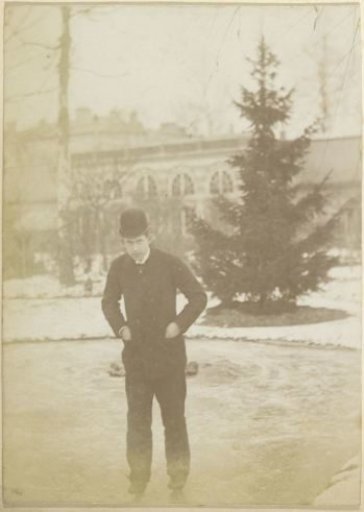 Man with a bowler hat skating on a pond near a villa in France