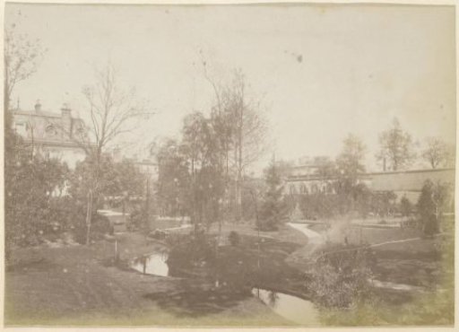 View of a garden with a villa, a pond, and an orangery in France
