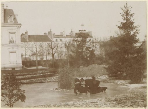 Two men in long coats on skates falling on a frozen pond in France