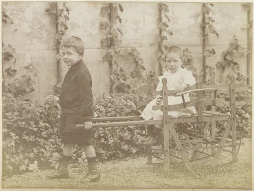 Portrait of two French children with a toy cart