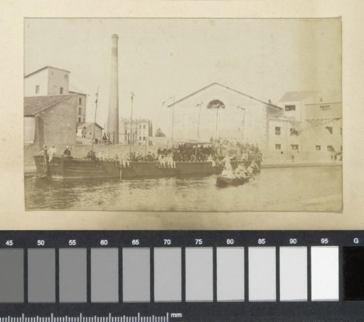 People on a quay at a factory in France