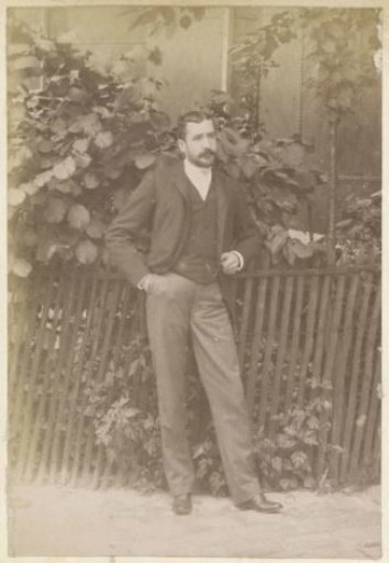 Portrait of a Man Standing by a Gate in France