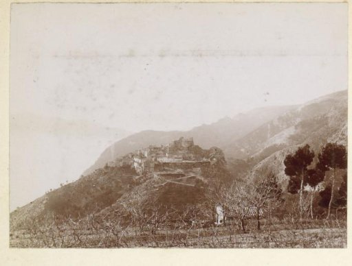 View of a mountain village with a castle ruin, probably on the coast of Southern France