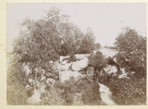 Walkers on a path between boulders, probably in southern France