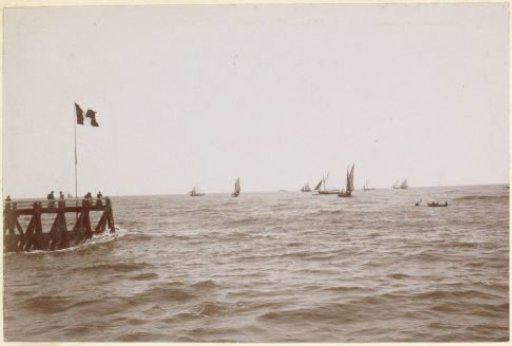 Sailing boats at sea and people on a pier, probably on the French coast