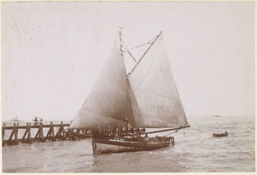 Sailing boat and rowing boat at a pier, probably on the French coast