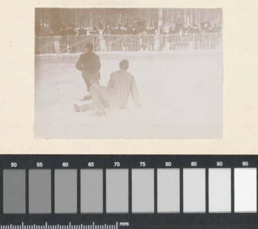 Fallen skaters on an ice-skating rink, probably in France