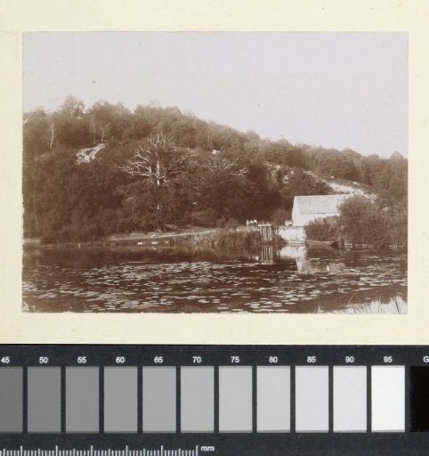 House on a waterway in a hilly landscape in France