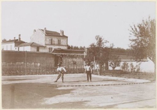 Two tennis players on a walled tennis court, probably in France