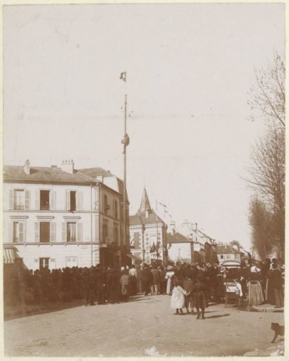 Spectators watching a man climb a flagpole in France
