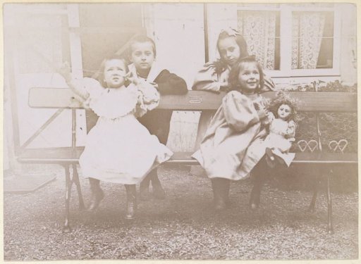 Group portrait of four French children by a bench