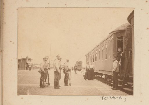 Soldiers and civilians on the platform by a train
