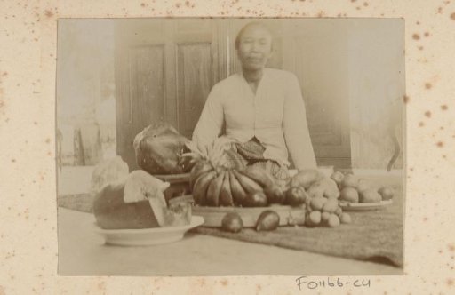 Dutch East Indies, still life of fruit on the floor with Indonesian woman