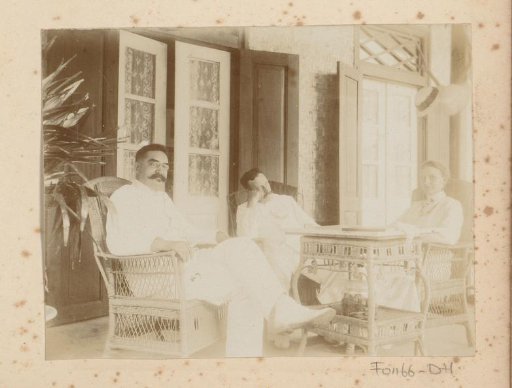 Two men and a woman sitting on a veranda