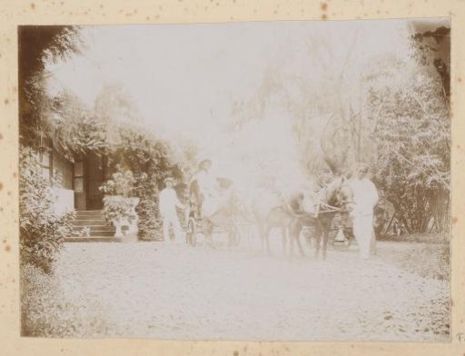 Men with horse and cart in front of a house