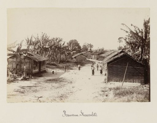 Street view with wooden houses, sandy road and children in Cameroon