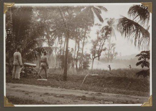 Police firemen of Tandjongkarang extinguishing a burning grass field