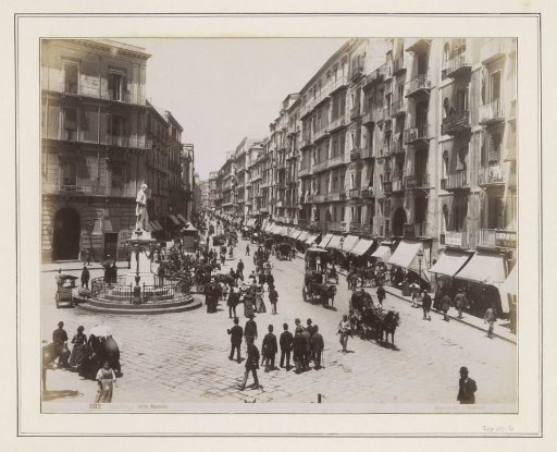 View of the Via Roma in Naples with a Statue, Shops, Horse-Drawn Carriages and Passers-by