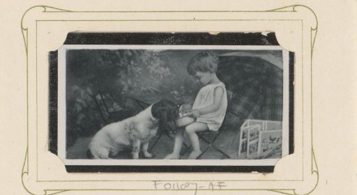 Child on a stool leading a dog